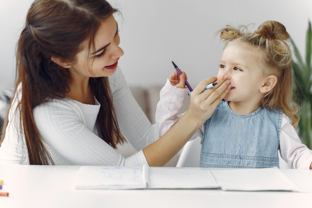 Happy mother and daughter bonding while doing homework together in a cozy indoor setting.